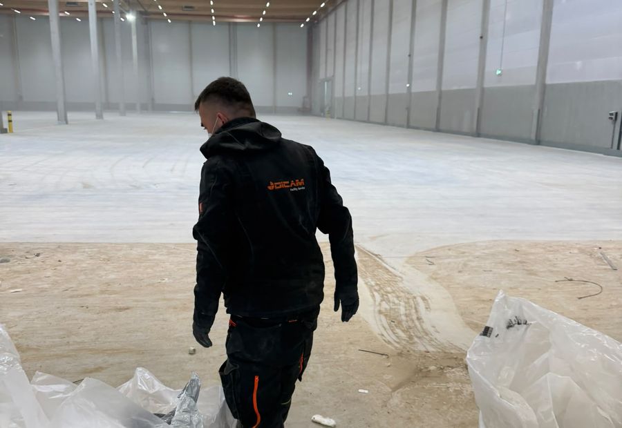 DICAM-Mitarbeiter räumt Bauschutt aus einer großen Industriehalle